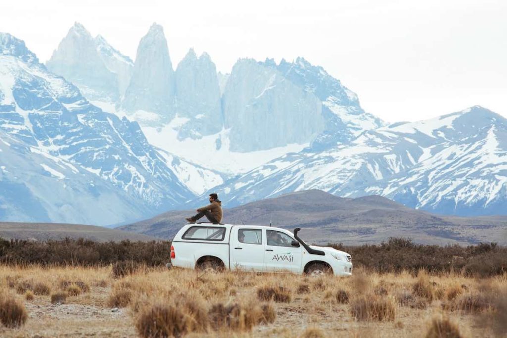 A truck from Awasi tours is parked with mountains in the background