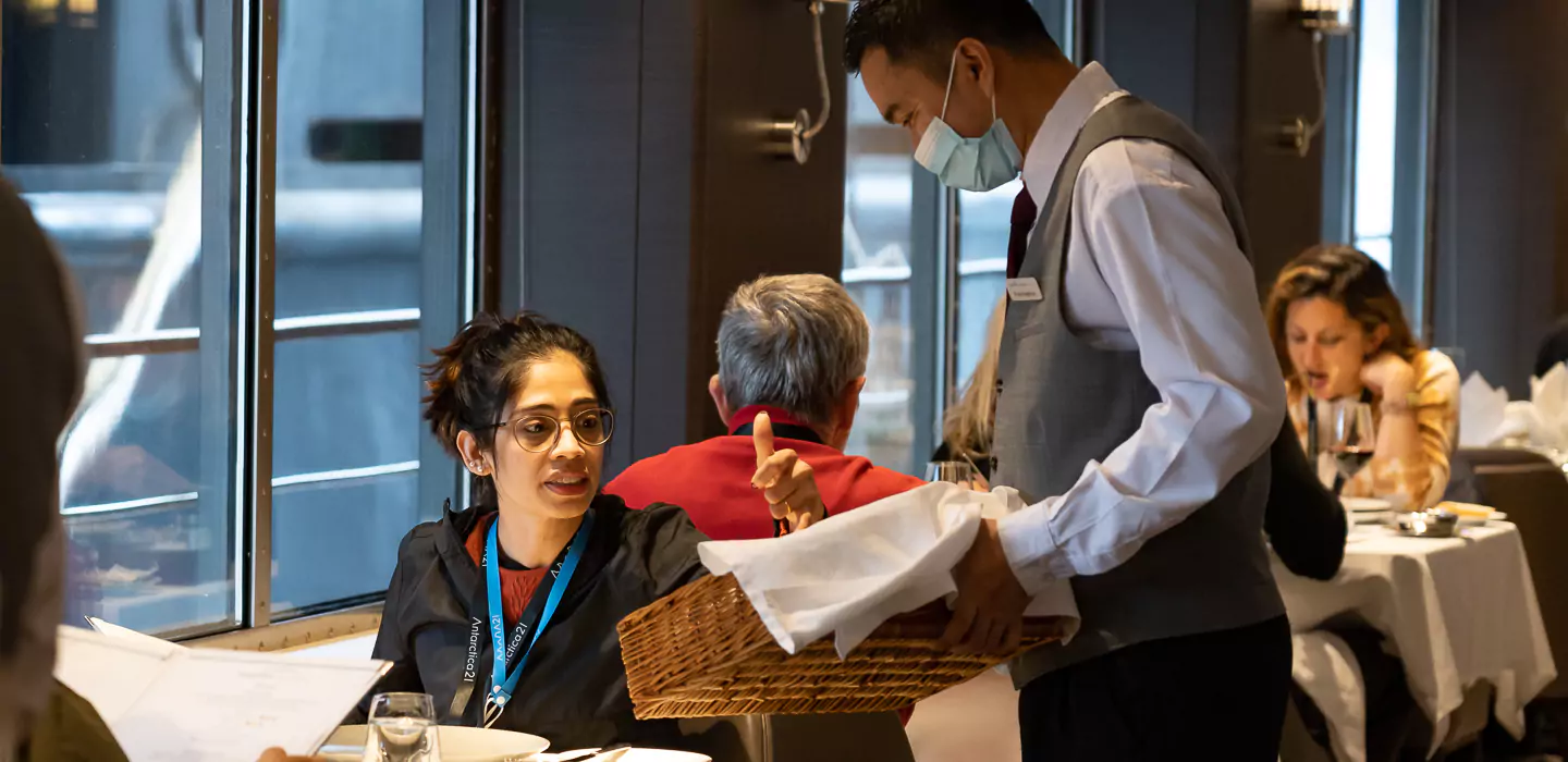 A woman speaks to a server aboard an Antarctic cruise ship